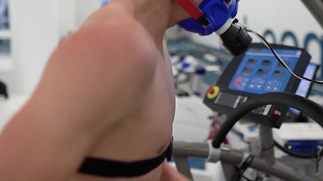 Athlete Testing In Modern Sport Science Laboratory. Professional Sport Analyzing Slow Motion. Man Running On Treadmill In Mask