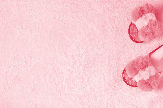 Homemade glamorous women's slippers on a fluffy pink carpet with place for text. Copy space.