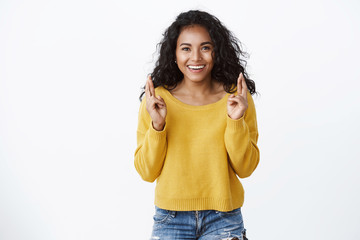 Lucky cheerful and confident african american pretty girl, wear yellow sweater, smiling happy cross fingers good luck, making wish believe dream will come true, standing encouraged white background