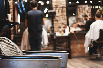 Chair for washing your hair in a barbershop. Barbershop interior. Brutal place. Leather armchair with metal upholstery. Selective focus.