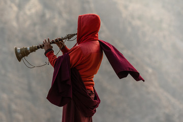 Buddhist monks from monastery are playing on traditional tubes among the Himalayas. . 