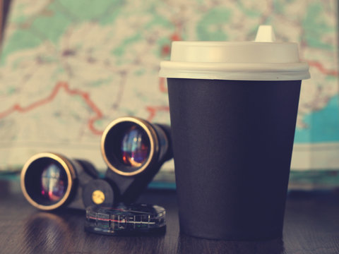 Black disposable coffee Cup and binoculars, travel