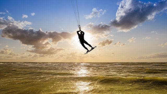 silhouette of an kitesurfer against a sunset