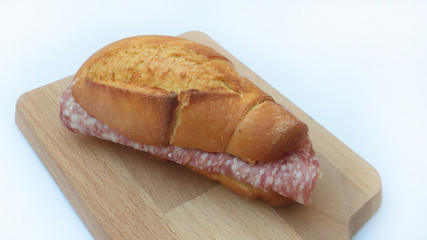sandwich with salami and wooden cutting board