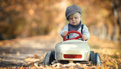 kleiner Junge mit Tretauto