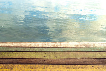 colour wood plank of pier with water of lake background.