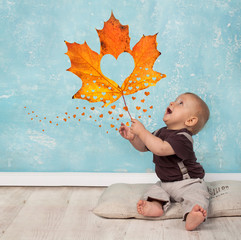 kleiner Junge mit Herbstblatt