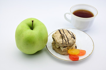 Photo on a white background apple, cake, cup with tea on a saucer. The concept of a delicious breakfast, lunch, healthy food.