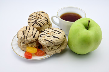 Photo on a white background apple, cake, cup with tea on a saucer. The concept of a delicious breakfast, lunch, healthy food.