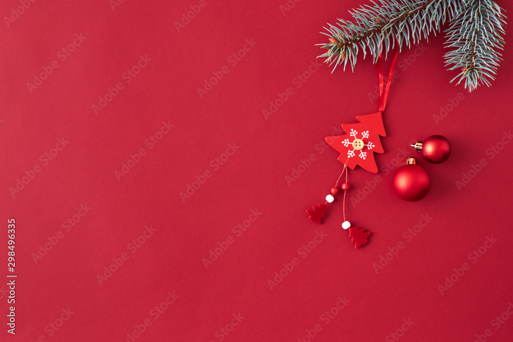 Wall mural flat lay border with branches spruce, red balls and christmas decoration on a red background