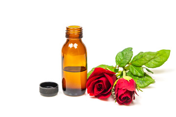 Rose oil in bottle and rose flower isolated on white background. Essential oil product concept.