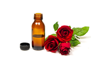 Rose oil in bottle and rose flower isolated on white background. Essential oil product concept.