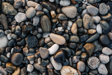 Gravel pattern of wet colored stones. Abstract nature pebbles background. Stone background. Sea peblles beach. Top view