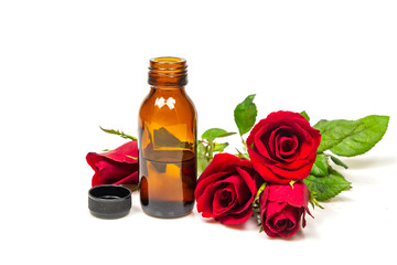 Rose oil in bottle and rose flower isolated on white background. Essential oil product concept.