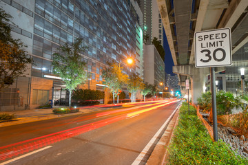 Downtown Miami night photo under metrorail with red light trails