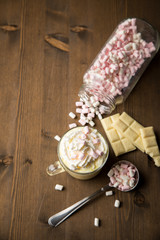Heiße, weiße Trinkschokolade mit Sahne, Schokoladen Tafel und Marshmellows auf dunkel Holz...
