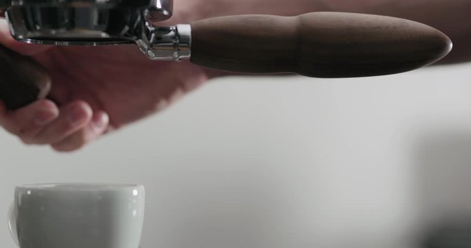 Slow motion side view of espresso extraction with bottomless portafilter