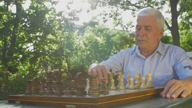 Old man opens the chess game with white pawn on E4
