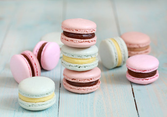Macaron or macaroon on blue background, colorful almond cookies with different filling. Selective focus