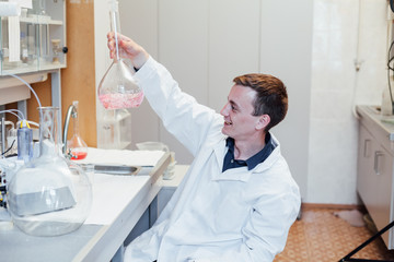 male scientist conducts chemical experiments with liquids in science lab