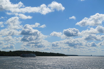 Russian beautiful Volga river landscape, floating passenger cruise ship on water and blue sky with clouds background on Sunny summer day
