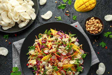 Crab salad with vegetables, radish, carrots, mango, pine nuts and prawn crackers