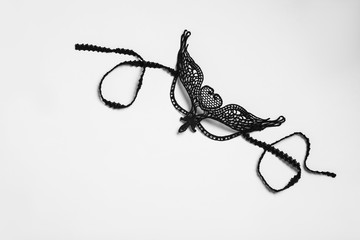 Black lace mask for sexual role play on white background, top view
