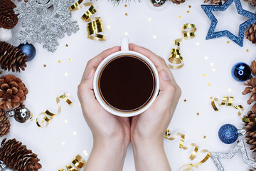 Woman hands with cup of coffee on Christmas and New Year background.