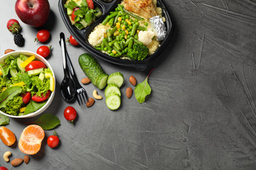 Flat lay composition with lunchbox on grey table, space for text. Healthy food delivery