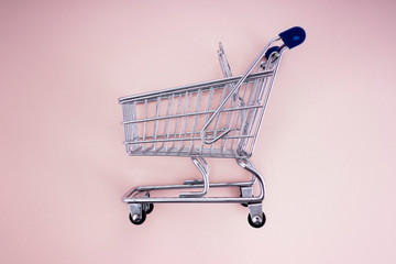 empty shopping cart over pink background