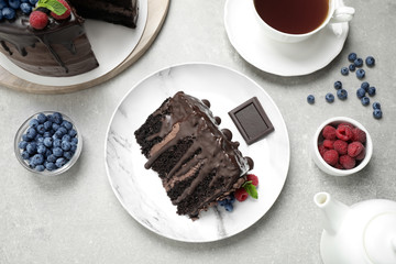 Delicious chocolate cake with fresh berries served on white table, flat lay