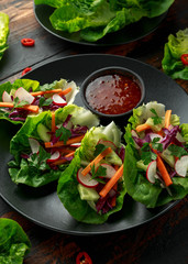Vegetable lettuce wraps with carrot, onion, radish, red cabbage, cucumber and sweet chilli sauce