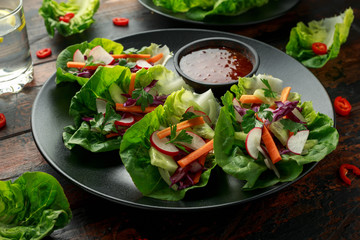 Vegetable lettuce wraps with carrot, onion, radish, red cabbage, cucumber and sweet chilli sauce