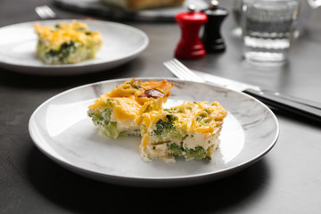 Pieces of tasty broccoli casserole on grey table