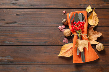 Cutlery and autumn decorations on wooden background, flat lay with space for text. Happy...