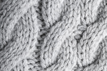 Grey knitted sweater as background, closeup view