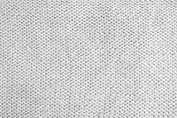 Grey knitted sweater as background, closeup view