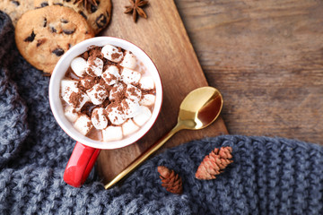 Flat lay composition of tasty cocoa with marshmallows on wooden table. Space for text