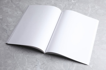 Blank open book on light grey marble background. Mock up for design