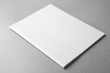 Blank book on light grey stone background. Mock up for design