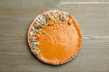 Delicious fresh homemade pumpkin pie on wooden table, top view