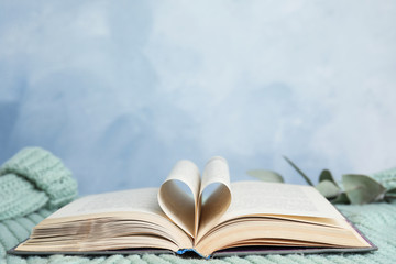 Heart made with pages in book on knitted sweater