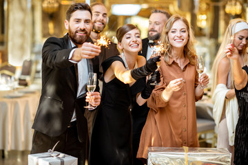 Well-dressed people celebrating New Year indoors