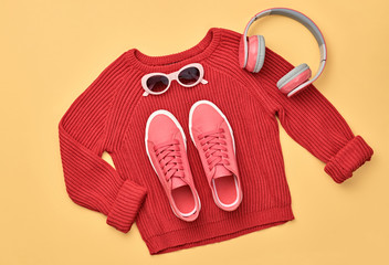 Hipster DJ trendy colorful autumn Outfit. Fall fashion minimal Flat lay. Red jumper, Stylish sneakers, headphones.Creative Woman Clothes Accessories layout, fall Girl fashionable autumnal orange color