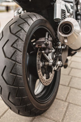 Closeup rear motorcycle wheel and exhaust pipe - motorcycle structure