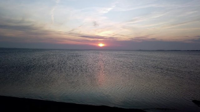 Biking along dyke at sunset in Fehmarn, POV 4k video footage
