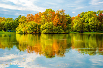 The trees painted in vibrant autumn colors on the shore of a quiet lake in the Park