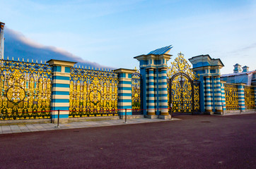 Ancient wrought fence, of the Catherine Palace with Golden decor on the metal bars.