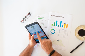 Businessman pointing graph on digital tablet at financial meeting about marketing