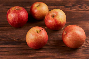 Fototapeta na wymiar Fresh ripe red apples on a brown wooden background